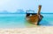 Tropical seascape with old fishing boat on beach.