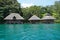 Tropical shore with thatched bungalows over water