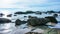 Tropical stone beach with clear water and blue sky