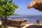 Tropical straw umbrella and sofas at beach bar