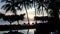 Tropical sunrise at the beach with dark silhouettes at foreground