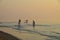 Tropical sunrisecoastal landscape waterscape with people fishing in the ocean water. Huay Yang, Thailand