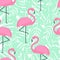 Tropical trendy seamless pattern with pink flamingos and mint green palm leaves.