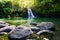 Tropical waterfall Lower Waikamoi Falls and a small crystal clear pond, inside of a dense tropical rainforest, off the Road to Han