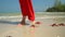 Tropical white sand with red starfish in clear water. Starfish on phu quoc Island. The woman in a red dress walks on the