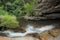 Tropical yoga session by beautiful Sticky Waterfall close to Chiang Mai in north Thailand.