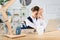 Troubled businesswoman sitting at desk in her office, leaning on her hands