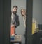 Troubled colleagues look out modern office with glass walls. Business couple at meeting. Bearded man and woman with