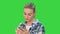 Troubled woman reading bad text news on phone touching her head in misery on a Green Screen, Chroma Key.