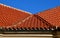 The trough of two roofs bent into a turn with Italian folded tiles and a metal gutter. you can see the ridge of the roof with conc