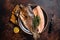 Trout roasted fillet, grilled fish on a plate with thyme and lemon. Dark background. Top view