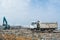 Truck and bulldozer at the garbage dump full of smoke, litter, plastic bottles,rubbish and trash at tropical island