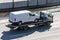 Truck carrier with mini van in the asphalt road