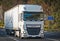 Truck carrying goods on a beautiful mountain road, one autumn day. The truck is DAF and belongs to the transport company Erka