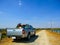 Truck is carrying the motorcycle on the gravel rural road