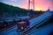 Truck with container rides on the road, railroad transportation, freight cars in industrial seaport at sunset