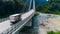 Truck crosses beautiful bridge in summer. Scene. Top view of truck carrying things driving across bridge on background