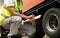 A truck driver holding clipboard his checking safety a truck wheels and tires