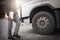 Truck driver holding clipboard his inspecting daily checklist safety of a truck wheels and tires. truck inspection and maintenance