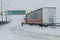 Truck driver shovels snow to free his truck