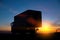 Truck driver transports cargo on a truck against the backdrop of sunset at night. The concept of compliance with the work and rest