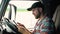 Truck drivers hand holding tablet checking the product list. Driver writing electronic log books. Right hand drive car