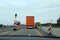 A truck drives through a construction site on the highway