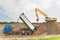 Truck and excavator together build a sound barrier