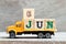 Truck hold block in word 6jun on wood background Concept for date 6 month June