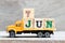 Truck hold block in word 7jun on wood background Concept for date 7 month June