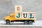 Truck hold block in word 9jul on wood background Concept for date 9 month July