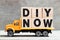 Truck hold block in word DIY abbreviation of do it yourself now on wood background