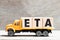 Truck hold block in word ETA abbreviation of estimated time of arrival on wood background