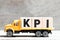 Truck hold block in word KPI Abbreviation of key performance indicator on wood background