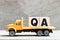 Truck hold block in word QA abbreviation of quality assurance or question and answer on wood background