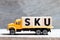 Truck hold block in word SKU abbreviation of stock keeping unit on wood background