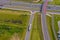 Truck logistic aerial. Trucks motion by the highway intersection road between fields. View from drone