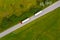 Truck logistic aerial. Two trucks motion by the road between fields. View from drone