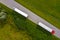 Truck logistic aerial. Two trucks motion by the road between fields. View from drone