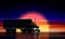 Truck moves on highway at sunset. Classic big rig semi truck with headlights and dry van on night road background of a sunset