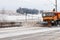 Truck plowing the thick ice formed on asphalt