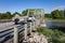 Truck Pulling Boat on Trailer on River Bridge