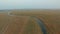 Truck rides along the river on a rural road.