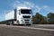 Truck on the road, front view, empty space on a white container - concept of cargo transportation, trucking industry