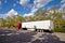 Truck on road with white blank container, blue sky, cargo transportation concept