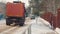 A truck with sand is driving on a snow-covered street. Rear view. Slow motion. Cleaning services