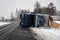 A truck with sawdust has turned over in the slippery roadway