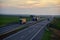 Truck with semi-trailer driving along highway on the sunset background. Goods delivery by roads. Services and Transport logistics