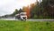 A truck with a semi-trailer tanker transports a dangerous cargo of fuel on a motorway slippery in the rain, industry