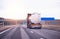 Truck with semi-trailer tanker transports dangerous goods on the highway on the background of sunset, industry. Copy space for